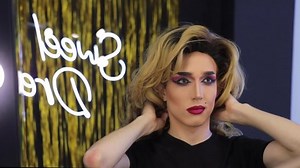 Young performer dressing as drag queen in front of mirror