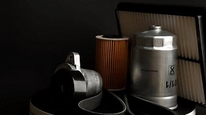 Car parts: oil filter, air filter, fuel filter, tension pulley and serpentine belt rotate slowly on black background, close-up. Concept of auto parts replacement, car maintenance, car service.