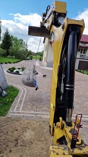 Girl swings in egg chair lifted by backhoe loader in Radzymin, Poland