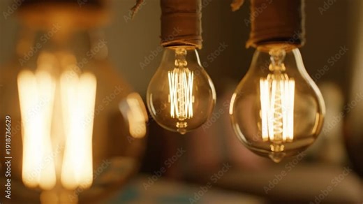 Close-up of three vintage Edison light bulbs hanging from a ceiling with a warm inviting glow