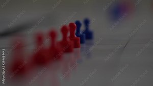 Blue and red magnets in shallow focus moving down in slow motion