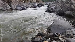 A fast flowing river from the mountains with naturally formed rocks