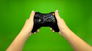 clip-1018976581-closeup-gamer-hands-playing-pressing-joystick-green