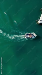 Vertical Screen: This vertical video captures a stunning aerial view of a fishing boat gliding through the ocean, leaving a trail behind. It's perfect for maritime or travel-related content.