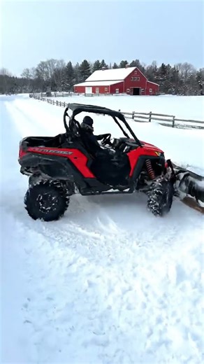 A side-by-side UTV with plow clearing snowy farm trails.