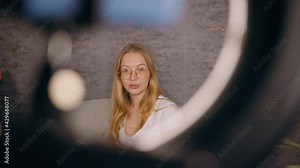 Female blogger live streaming her content using ring light and mobile phone