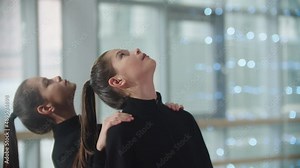 Little girl twins standing in the studio and synchronously looks up