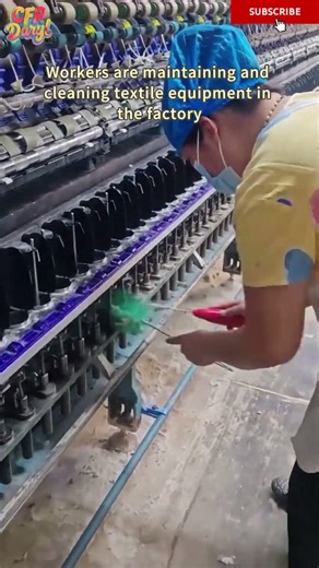 Workers are maintaining and cleaning textile equipment in the factory