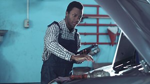 Mechanic checking a car motor with computer - Free Stock Video