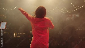 concert of young singer woman, rear view of female figure, view from stage to audience hall