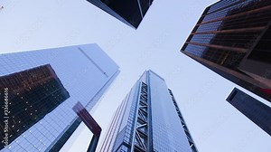 Low angle shot looking up at skyscrapers on all sides in the financial district of New York City. Camera Rotate