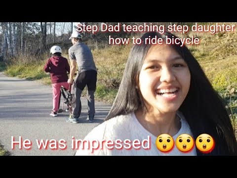Step Dad teaching step daughters how to ride a bicycle