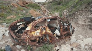 Rusty wrecked car on the beach