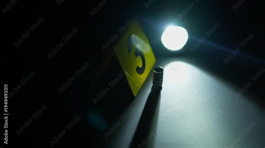 Bullet shell casing on the black night club surface floor. Mass shooting violent crime with firearm concept. Crime Scene restricted area for investigation with yellow evidence markers.