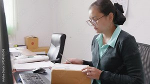 Asian woman checks package ordered through online store