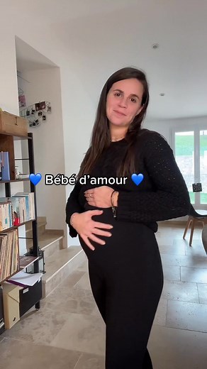 Pregnant Woman in Modern Living Room Cradling Baby Bump