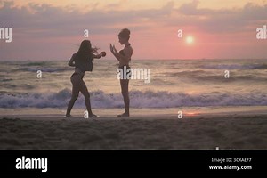 Karate girls in bikini on the beach, silhouette during training. The concept of a healthy lifestyle Stock Video Footage - Alamy