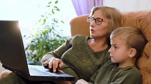 clip-1100375731-grandson-showing-grandparents-how-use-computer