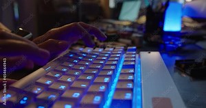 computer hands typing on keyboard browsing online gaming late at night computer programmer using keyboard with blue backlight