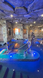 Pool and Speakeasy under the house. We designed and built this Insane Pool and Speakeasy, with lots of seating for parties, a huge spa, natural rock waterfalls, 48 tons of rock suspended above your head, a custom bronze sculpture capturing the Client's kids in their childhood glory at the beach, and 1920’s décor for the speakeasy. #speakeasy #insanepools #lucaslagoons #insane #poolbuilder #mancave | Lucas Lagoons Design