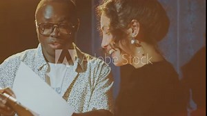 African American stand-up show host discussing performance script with young female comedian standing on stage under spotlight Stock Video