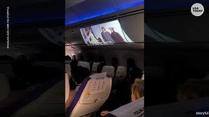 Plane passenger projects in-flight movie on overhead bin
