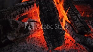 Close-up of burning logs in a fire in the backyard of a house, real-time video, cozy night fires