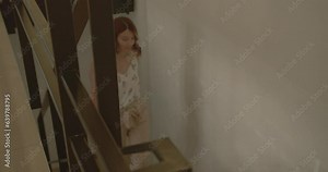 Lady climbing up the stairs in the office upside floor. She is happy and eager to work, summertime