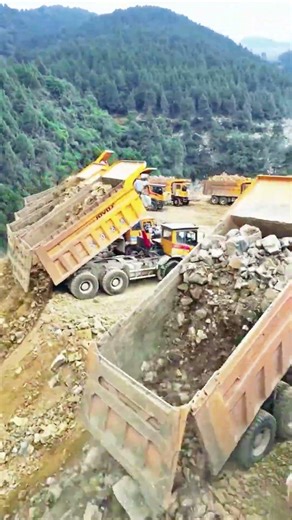 Dozens of heavy duty trucks unloading earthwork on site #infrastructure #mountains #technology