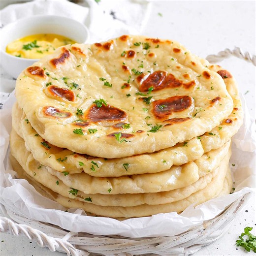 Who else loves Naan? Ingredients 2 cups (250 g) bread flour ½ cup (120 g) warm water ⅓ cup (80 g) plain full fat yogurt 1 tsp (3 g) instant yeast 2 tsp (8 g) sugar ¾ tsp (4 g) salt 2 tbsp (30 g) unsalted butter, melted and cooled, or 2 tbsp (30 g) neutral oil Melted butter or garlic butter, for brushing Chopped parsley or cilantro, optional #naan