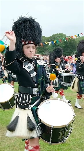 A close-up of the Lonach Highlanders, led by the Lonach Pipe Band, marching around the Games field as they arrived at the 2025 Lonach Highland Games. This was part of the Lonach Gathering, held on Saturday 23rd August 2025 at Bellabeg, within the Cairngorms National Park in Scotland. The march is led by the 3 Lonach Highlanders with their Lochaber axes, then the Lonach Pipe band, led by Drum Majors Neil Jamieson and Bill Barclay, playing the tune The Piobaireachd (Pibroch) of Donald Dhu. The Lon