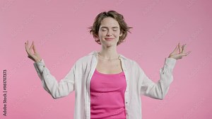 Tranquil woman relaxing, meditating, refuses stress. Charming lady breathes deeply, calms down, pink studio background. Yoga, moral balance, zen concept.