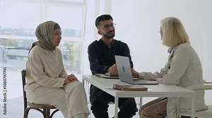 Arab Middle Eastern couple discussing infertility problems with a senior experienced female doctor. Positive pregnancy planning, doctor consulting a couple during a hospital visit. Healthcare