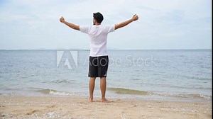 Relax asian man barefoot walking on tropical summer beach feeling fresh and freedom on holiday. Enjoyment barefoot walk outdoor with freedom. Relaxation Travel Concept.