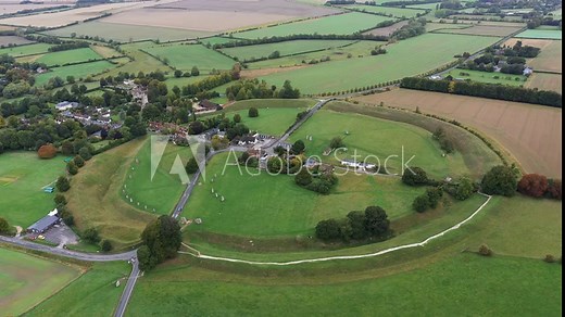 Avebury, Wiltshire, England. Aerial of village and huge prehistoric megalithic stone circle standing stones and henge complex. View to NW. Video static