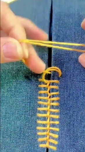 creates decorative embroidery pattern on dark blue fabric