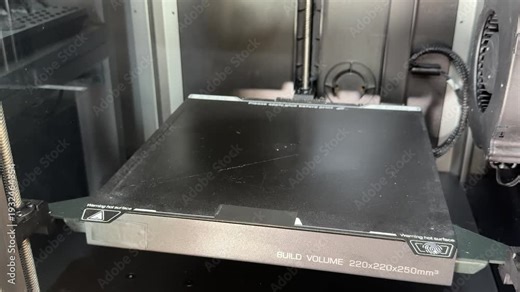 3D printer build plate rises along the vertical axis during setup, showing precise mechanical movement and calibration.