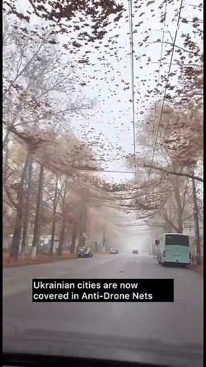 Ukrainian cities are now covered in anti-drone nets Multiple Ukrainian cities have begun installing large anti-drone nets over streets, buildings, and public areas as protection against Russian drone attacks. These nets are designed to stop or slow down incoming drones, preventing them from hitting civilian targets and reducing damage from explosive payloads. #wsmirror #ukraine #war #kyiv #drone #news #worldnews | Washington Mirror