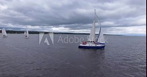 Sailing in the wind. Full sails, very strong wind. Ocean race, real adventure. Storm day. Aerial view on Sailboat. Yacht sailing on opened sea. Stormy disturbed water. Rainy weather. Sailing boat.