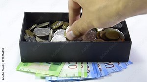 Take coins from a coin box with your hand. Russian rubles.