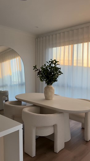 Our Odette Dining Table, paired with Leva Boucle Chairs and our stunning Mansour Arched Mirror. As styled here by @kaitlinknightt | James Lane