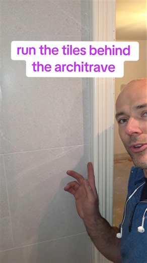 this is something you must do.run the tiles in behind the architrave, this will make it look cleaner