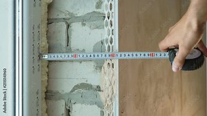 Closeup man hands checking distance between window and wall with measure tape. Repairs, building, design concept Stock Video