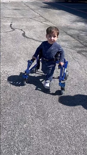 Child with Spina Bifida learns how to use a reverse walker