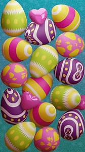 A looping vertical 3D video features colorful Easter eggs and pink heart balloons falling to the ground and then falling again. Digitally 3D rendered animation in the concept of Happy Easter Day.