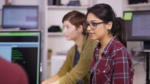 4K Young computer experts working in office with lots of computers. Could be hackers or programming technicians. Shot on RED Epic. UK - April, 2016
