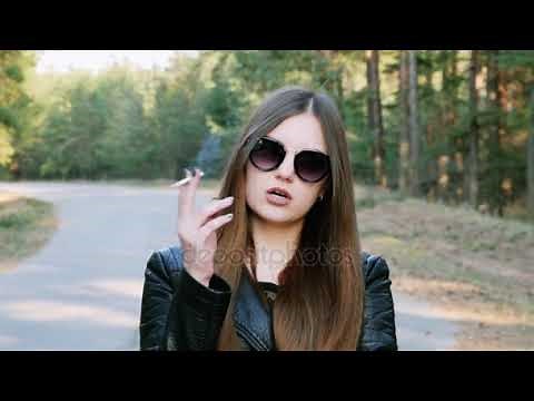 Portrait of pretty cheeky woman, smoking a cigarette and looking at the camera with glasses in slow