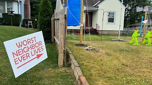 'Worst Neighbor' sign stays up, tarp fence coming down after intervention in neighbor feud