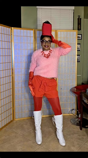 Valentine's Day Styles Showcase Inspo 💖 Part 2 Short Shorts: Vintage Inspired 💕 This bold and vibrant ensemble is a fashion statement showcasing a playful and deliberate use of color blocking, specifically the pairing of pink and orange which sit side-by-side on the color wheel and create a harmonious, energetic look. The white go-go boots add a retro 1960s or 1970s vibe and help break up the bright colors, making the look pop even more. White accessories evoke a 1960s Mod or 1970s Disco aesth