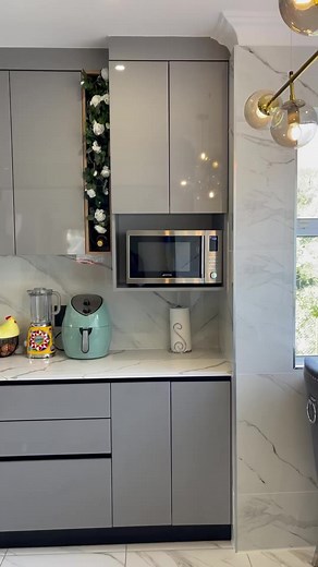 Modern kitchen ,cloudy white top,alluminium doors with black glasses,lights | Amachunu Interior and Design